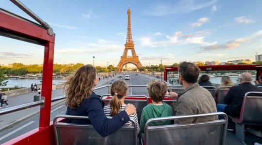 Famille de quatre personnes vue de dos dans un bus à impériale découvert admirant la Tour Eiffel lors d'une journée ensoleillée à Paris
